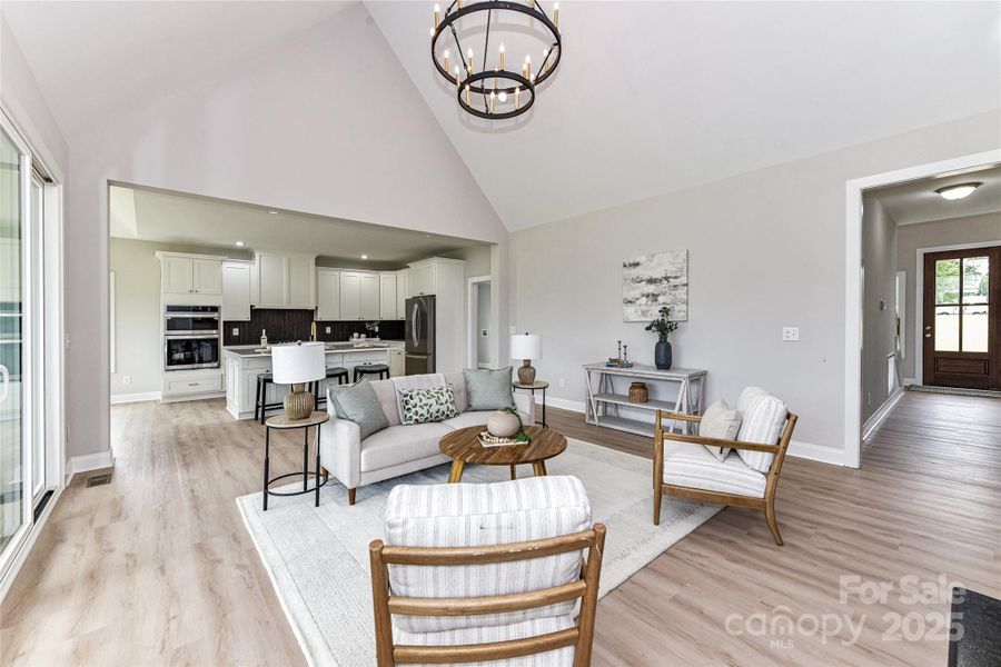 Vaulted Great Room features gas, ship lap fireplace, custom light fixture, LVP floors with access to covered deck & open to Kitchen! Vaulted Great Room features gas, ship lap fireplace, custom light fixture, LVP floors with access to covered deck & open to Kitchen!