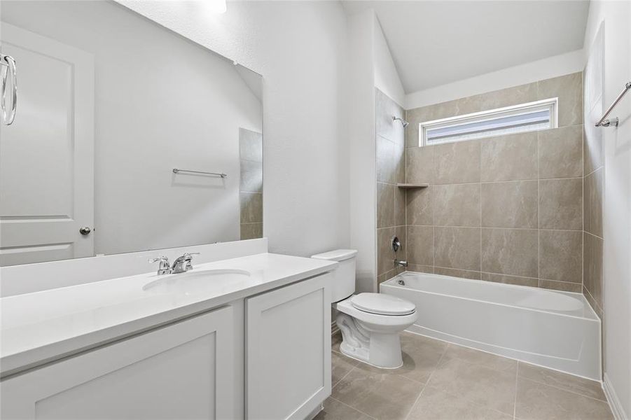 Full bathroom featuring vanity, bathtub / shower combination, lofted ceiling, and light tile patterned floors