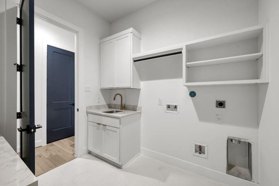 Laundry room with built-in cabinetry and sink for convenience. Laundry room with built-in cabinetry and sink for convenience.