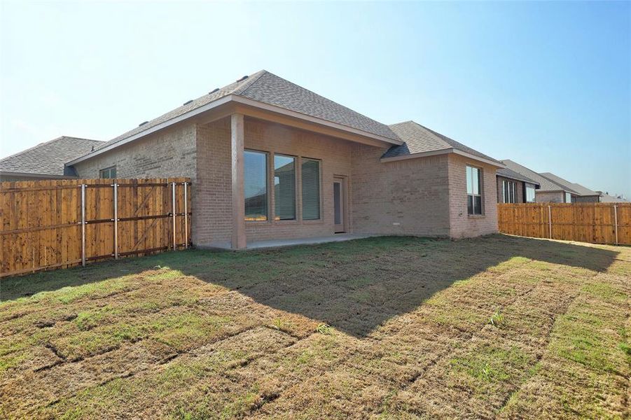 Rear view of property with a fenced backyard, a patio, brick siding, and roof with shingles Rear view of property with a fenced backyard, a patio, brick siding, and roof with shingles