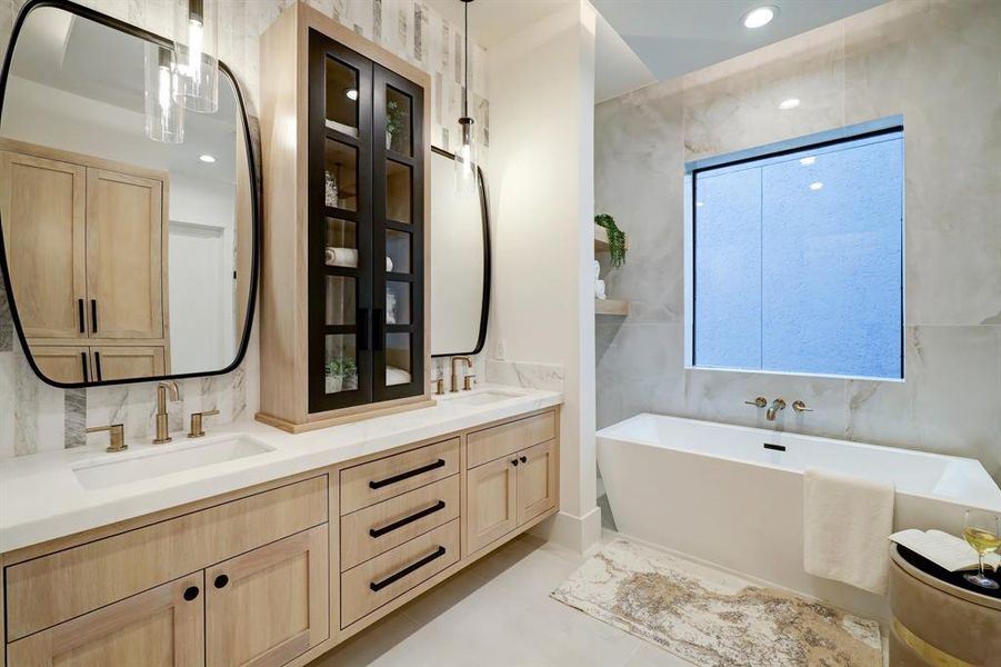 Experience the elegance of this primary bathroom, featuring chic custom pendant lighting, warm oak wood accents, and luxurious marble detailing. Unwind in the deep soaking tub for the ultimate relaxation.