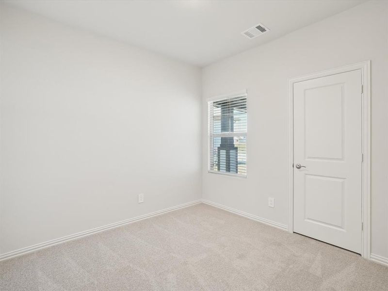 Spare room featuring light carpet and baseboards