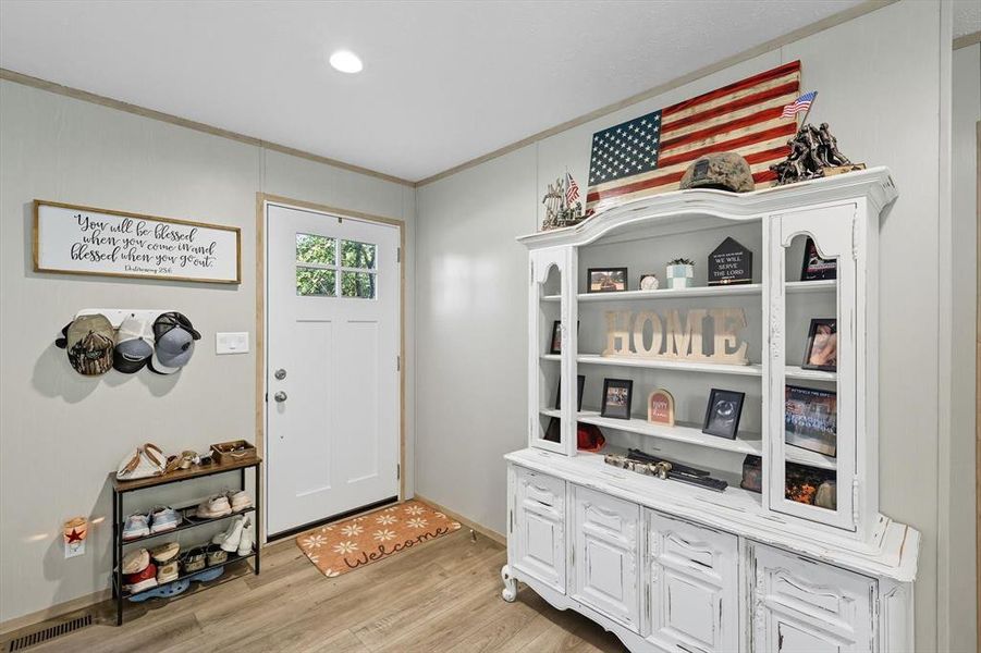 Foyer with crown molding, light wood-style flooring, and recessed lighting Foyer with crown molding, light wood-style flooring, and recessed lighting