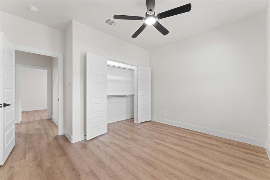 Unfurnished bedroom featuring light wood-style flooring, a closet, baseboards, and a ceiling fan Unfurnished bedroom featuring light wood-style flooring, a closet, baseboards, and a ceiling fan