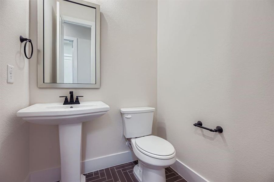 Half bath with a textured wall and tile patterned flooring Half bath with a textured wall and tile patterned flooring