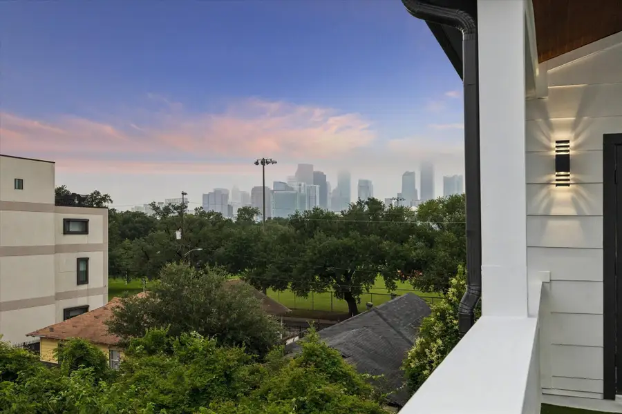 This photo showcases a balcony view with a scenic overlook of a lush park and a city skyline in the distance, perfect for enjoying sunsets and city lights. This photo showcases a balcony view with a scenic overlook of a lush park and a city skyline in the distance, perfect for enjoying sunsets and city lights.