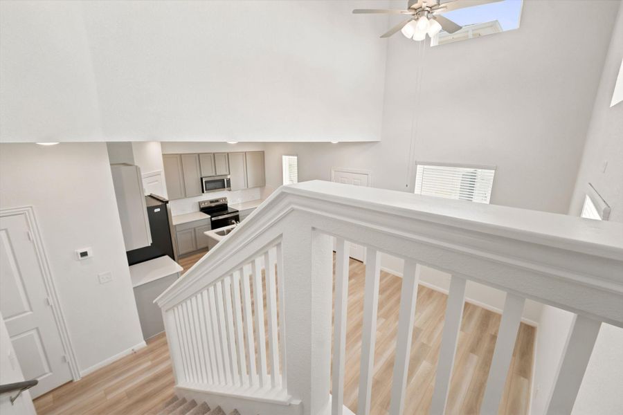 High ceilings and clean architectural lines define this multi-level perspective looking down from the staircase.
