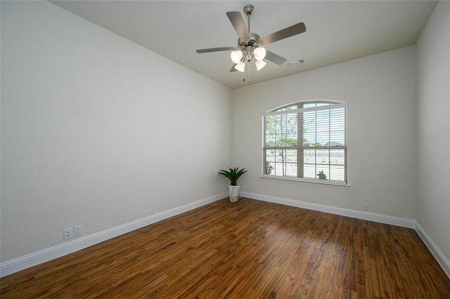 Unfurnished room with dark hardwood / wood-style floors and ceiling fan