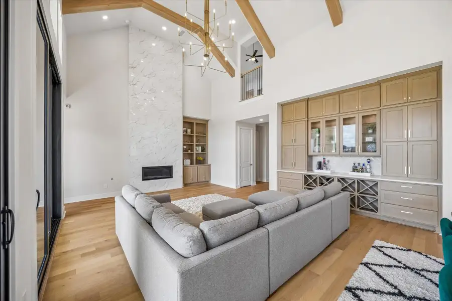 THIS SPACIOUS FAMILY ROOM FEATURES A DRAMATIC FIREPLACE SURROUND, CUSTOM BUILT-INS, AND DOUBLE-HEIGHT CEILINGS. UPPER-LEVEL OPENINGS AND CLEAN ARCHITECTURAL LINES ENHANCE THE ROOM’S OPEN FEEL. THIS SPACIOUS FAMILY ROOM FEATURES A DRAMATIC FIREPLACE SURROUND, CUSTOM BUILT-INS, AND DOUBLE-HEIGHT CEILINGS. UPPER-LEVEL OPENINGS AND CLEAN ARCHITECTURAL LINES ENHANCE THE ROOM’S OPEN FEEL.