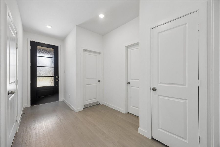 Crisp, clean finishes and LVP flooring give the entry a fresh modern feel, setting the tone for the bright, easygoing spaces throughout.