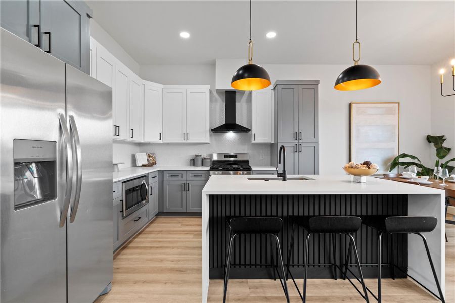 The heart of the home stuns with a fluted black island, waterfall quartz countertops, and dual-tone shaker cabinetry in slate and white.