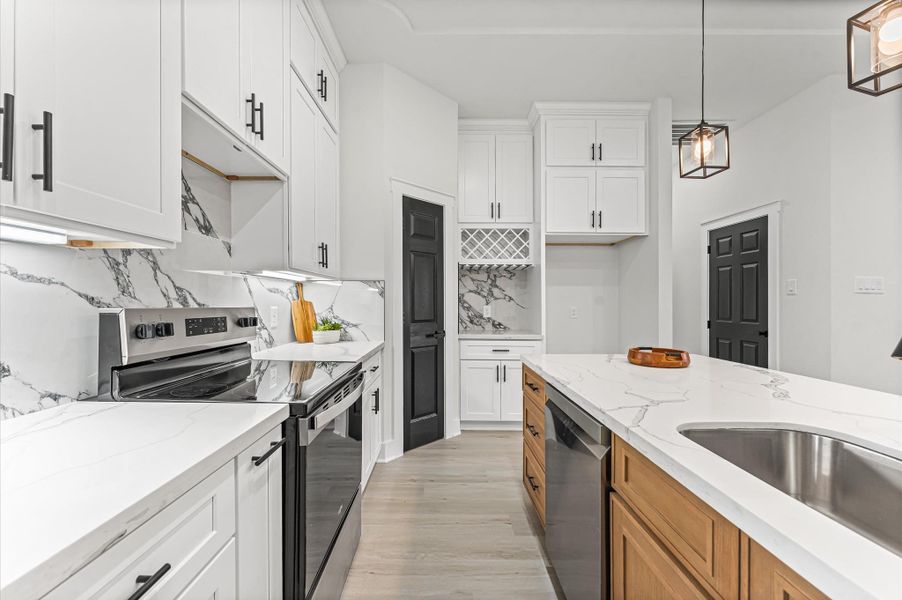 Spacious kitchen featuring abundant cabinetry, center island, and plenty of counter space for meal prep and gatherings. Photos are representative of the same floor plan built by this builder. Finishes will be the same or similar.