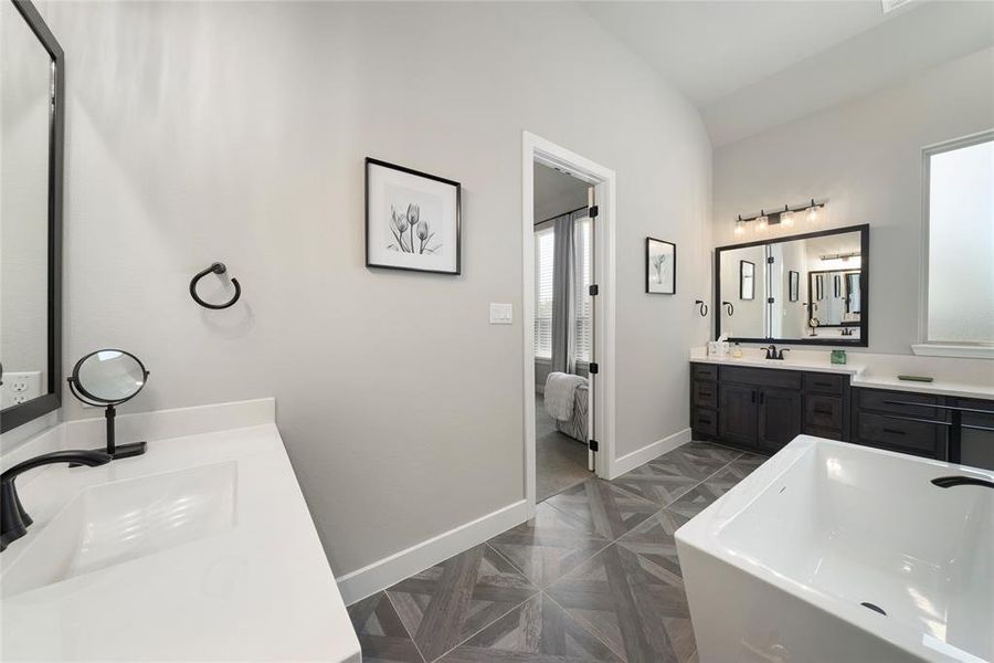 Bathroom with vanity, a bathtub, parquet flooring, and vaulted ceiling