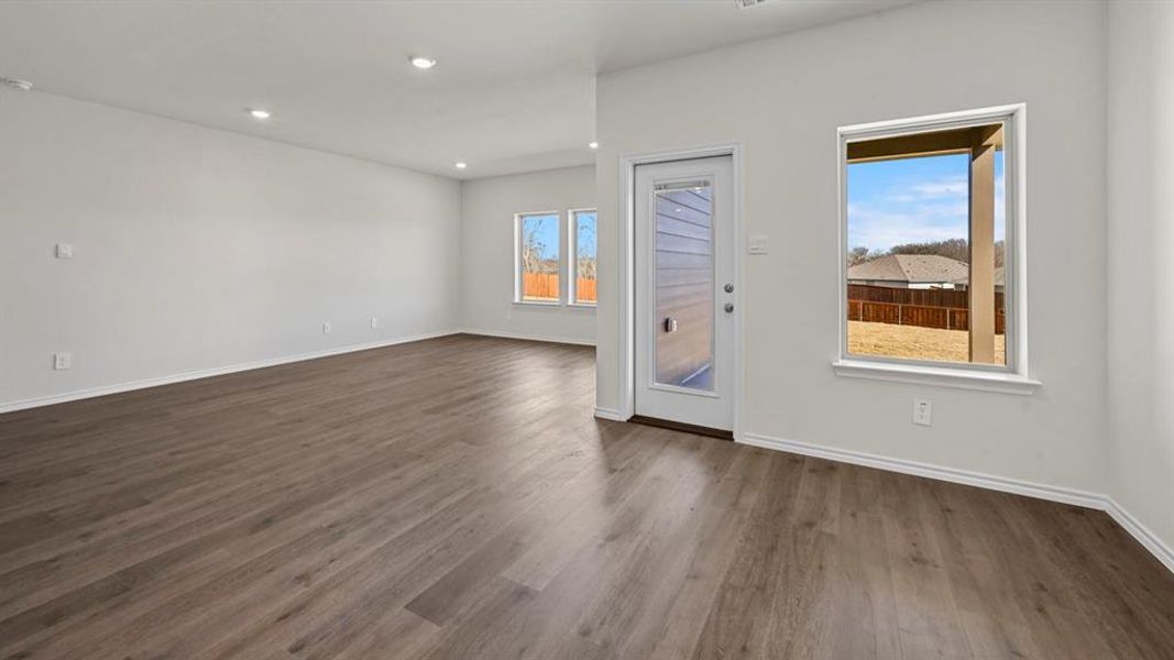 Spare room featuring plenty of natural light, dark wood-type flooring, and recessed lighting