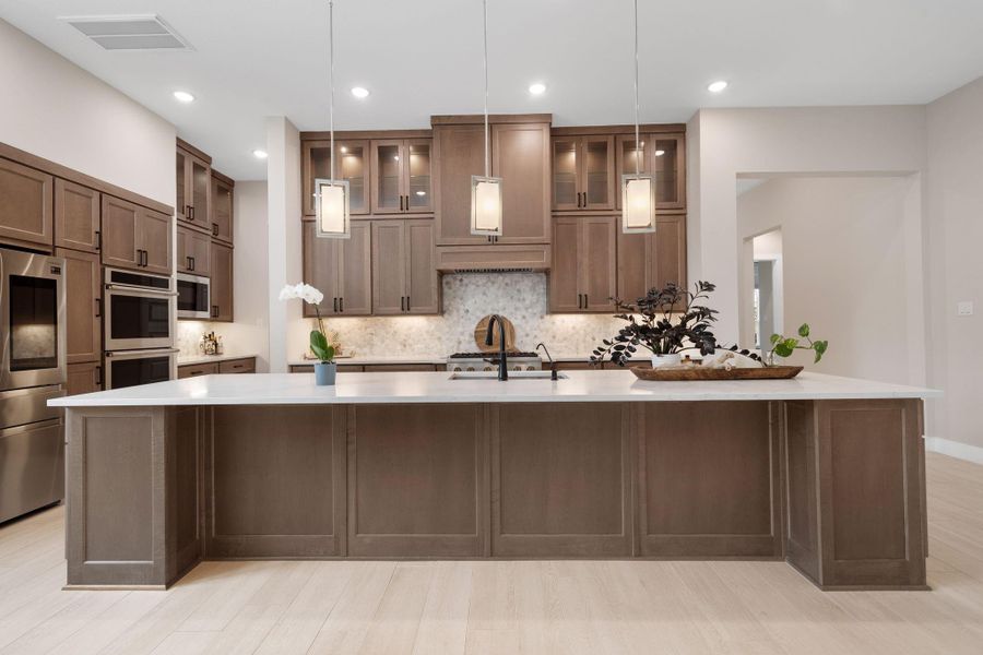 Elegant pendant lighting above the island adds a touch of sophistication, while the open layout allows for easy flow into the dining and living areas, making this space ideal for both cooking and gathering. Elegant pendant lighting above the island adds a touch of sophistication, while the open layout allows for easy flow into the dining and living areas, making this space ideal for both cooking and gathering.