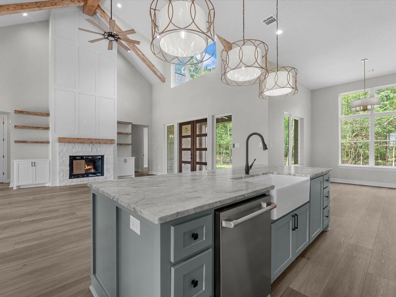 Chef’s kitchen with oversized island, custom cabinetry, and statement lighting.