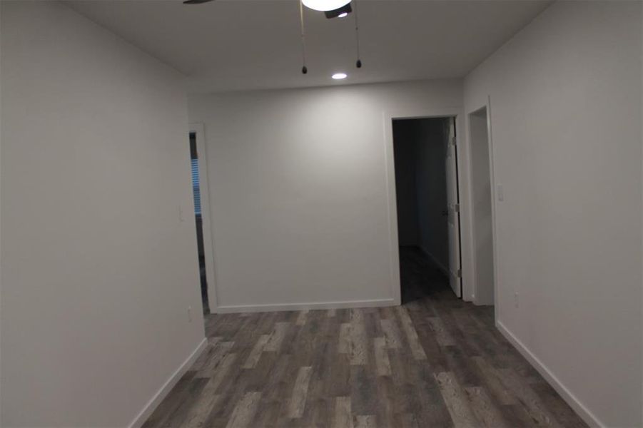 Empty room featuring dark wood-style flooring and ceiling fan
