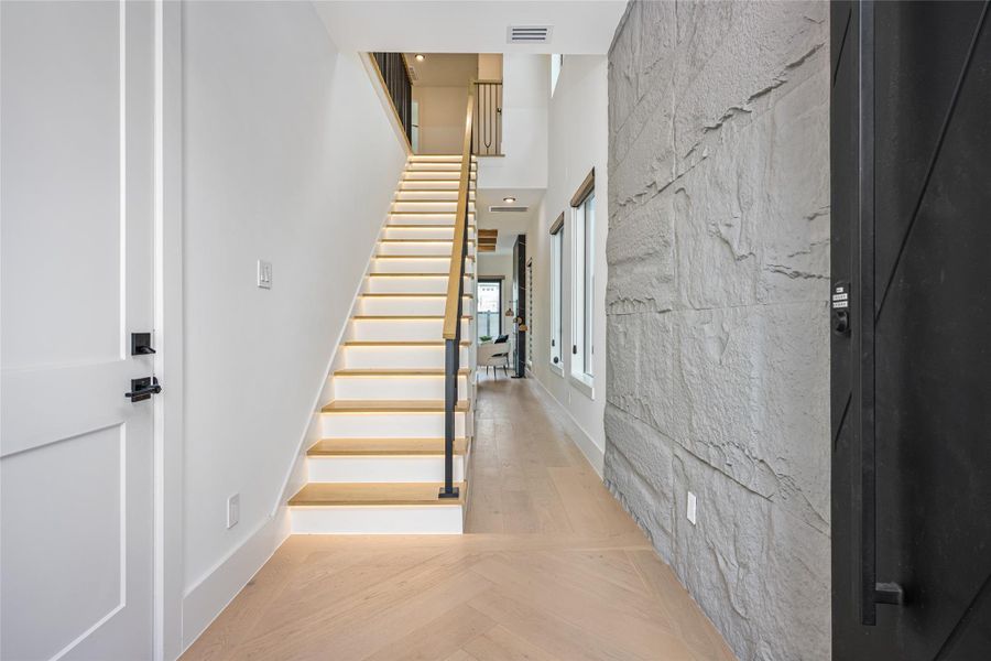 Optional stone fascia, a custom chandelier, and rich engineered wood floors create a dramatic, yet warm entry.