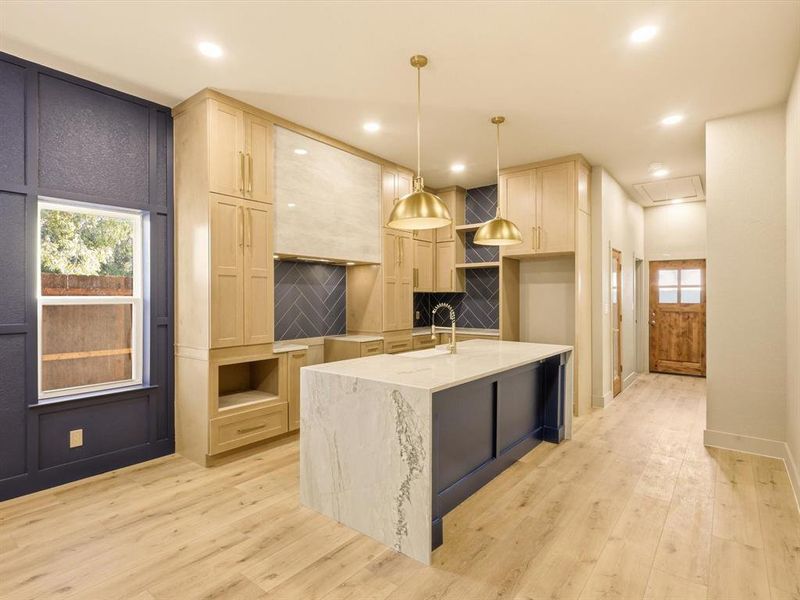 Kitchen with white oak cabinetry, Quartzite counters, pendant lighting, light wood-style flooring, and recessed lighting