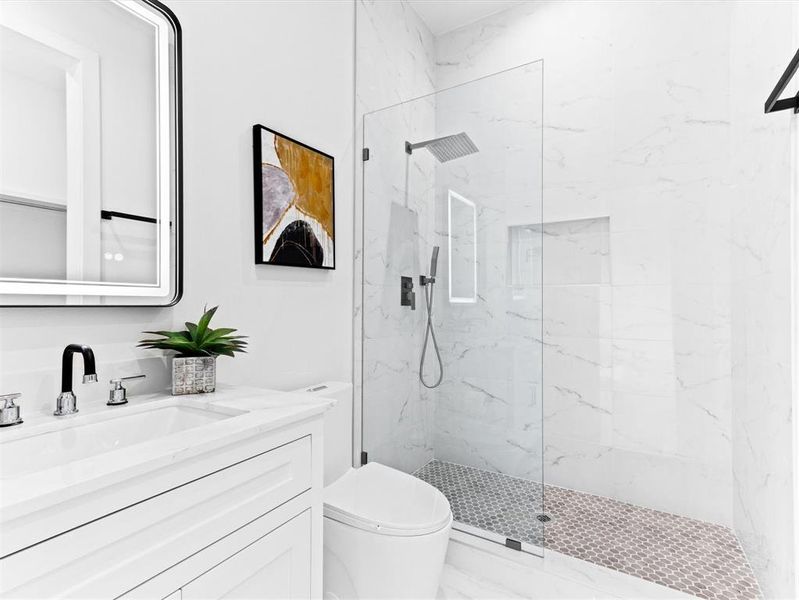 Bathroom with walk in shower, vanity, and toilet