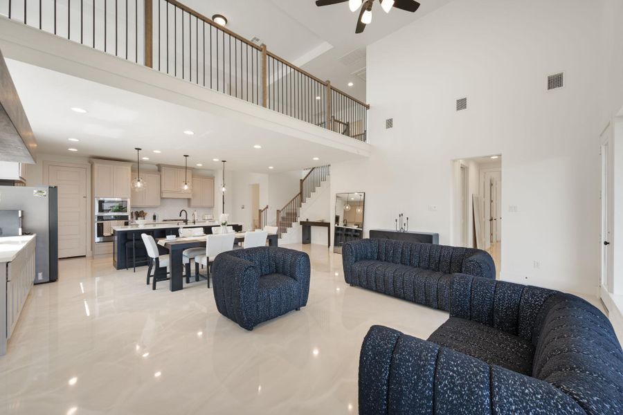A spacious, luminous open-concept area combines living, dining, and kitchen spaces with a grand two-story ceiling. A spacious, luminous open-concept area combines living, dining, and kitchen spaces with a grand two-story ceiling.