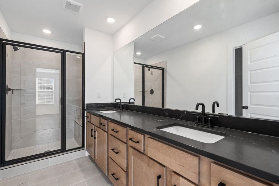Dual vanity with black countertops and integrated sinks