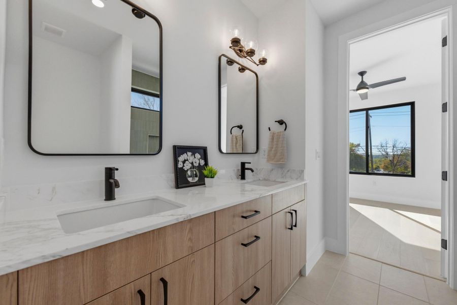 Bathroom featuring double vanity, light tile patterned floors, and ceiling fan