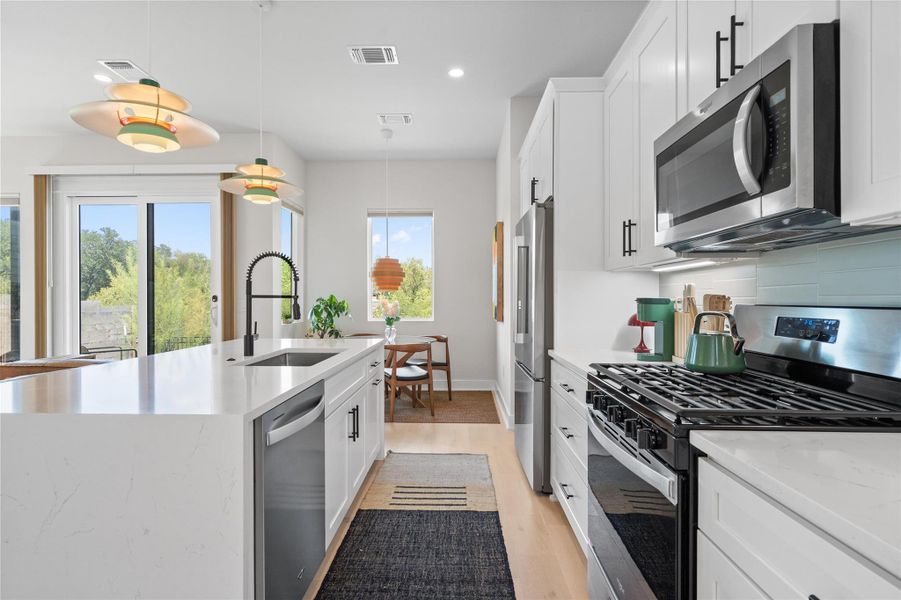 A pristine culinary space features sleek stainless steel appliances and an inviting kitchen island. A pristine culinary space features sleek stainless steel appliances and an inviting kitchen island.