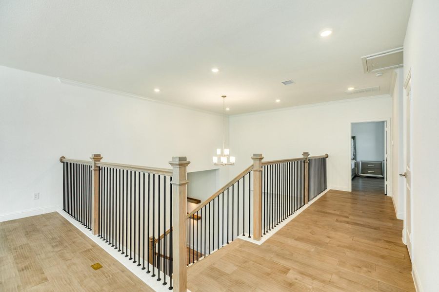 The upstairs area features an expansive, open-concept floor plan centered around a large game room, which offers the flexibility to be partitioned for a dedicated media room. Highlights include hardwood flooring throughout, recessed lighting, and an elegant chandelier located in the foyer.