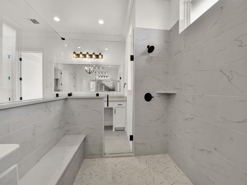 Full bath featuring an inviting chandelier, tiled shower, vanity, visible vents, and recessed lighting Full bath featuring an inviting chandelier, tiled shower, vanity, visible vents, and recessed lighting