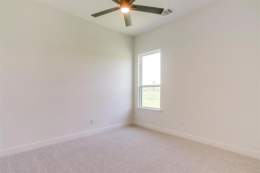 Empty room with carpet flooring and ceiling fan