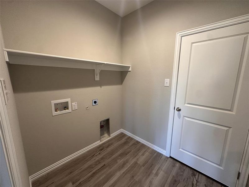 Clothes washing area with electric dryer hookup, hookup for a washing machine, hookup for a gas dryer, and dark hardwood / wood-style flooring