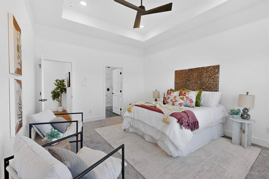 Carpeted bedroom with a raised ceiling, connected bathroom, a towering ceiling, ceiling fan, and recessed lighting