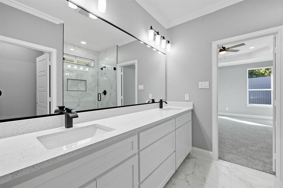 Bathroom with light marble finish flooring, crown molding, a marble finish shower, double vanity, and ceiling fan Bathroom with light marble finish flooring, crown molding, a marble finish shower, double vanity, and ceiling fan