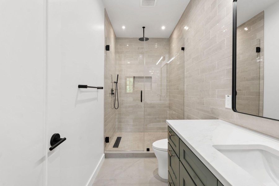 A well-appointed bath boasts a spacious walk-in shower with sleek fixtures, alongside a generous vanity. A well-appointed bath boasts a spacious walk-in shower with sleek fixtures, alongside a generous vanity.