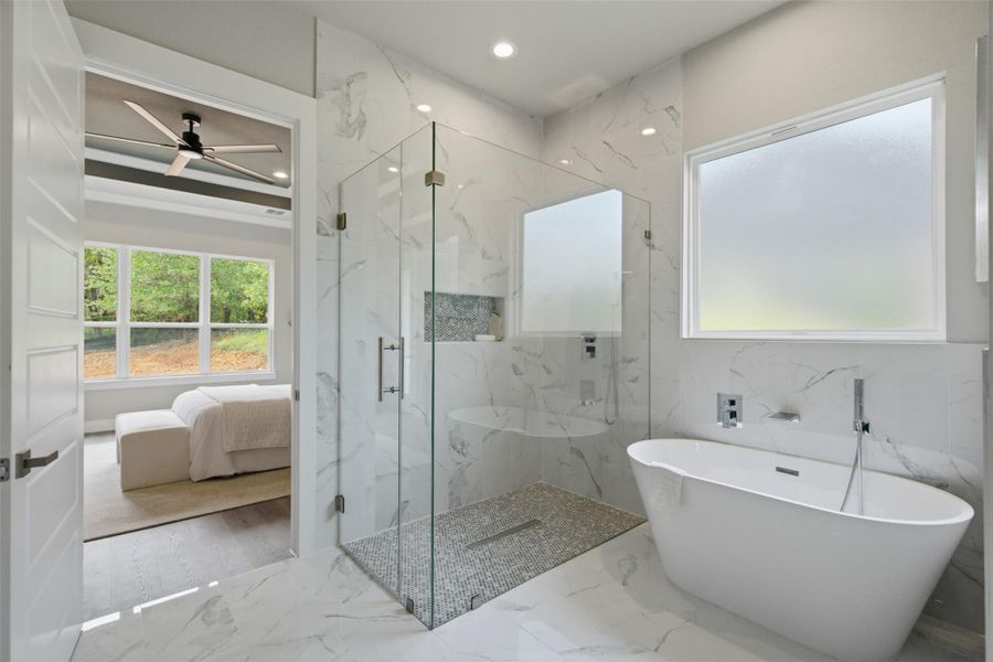 Indulge in this serene primary bathroom featuring a freestanding tub and a glass-enclosed shower. Indulge in this serene primary bathroom featuring a freestanding tub and a glass-enclosed shower.