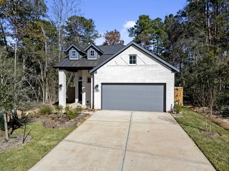 Front exterior of a new home in The Woodlands Hills, Willis, TX, highlighting curb appeal (Image 2). Front exterior of a new home in The Woodlands Hills, Willis, TX, highlighting curb appeal (Image 2).