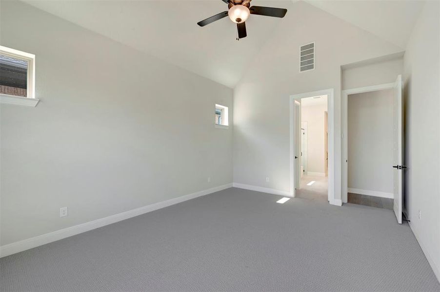 Unfurnished bedroom featuring carpet, lofted ceiling, and a ceiling fan