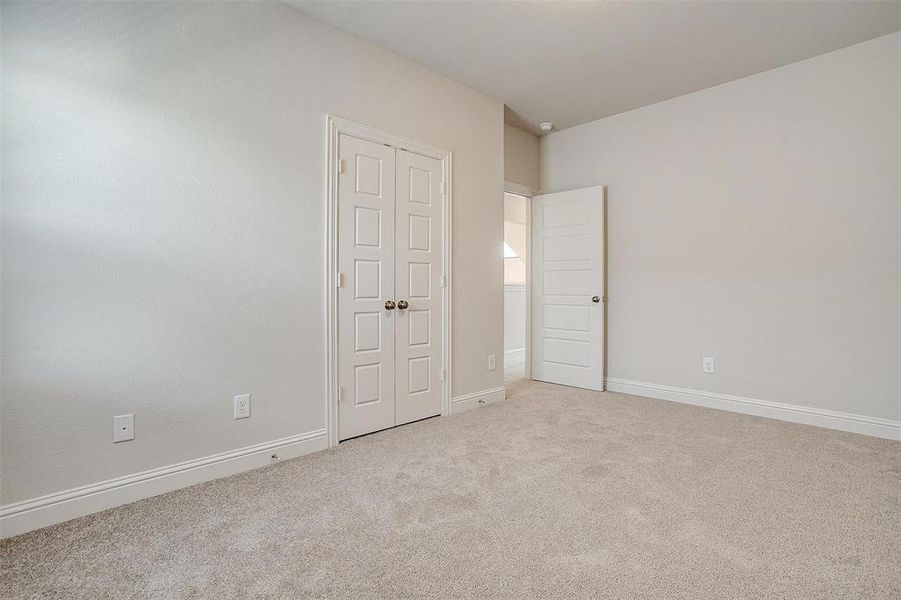 Unfurnished bedroom with light colored carpet and a closet