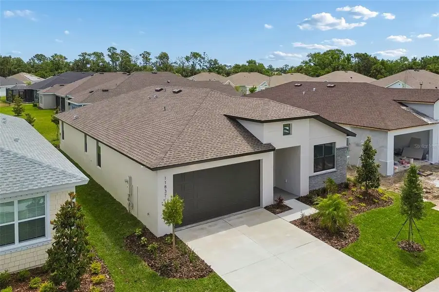 Front exterior of a new home in Isles at Bayview, Parrish, FL, highlighting curb appeal (Image 26). Front exterior of a new home in Isles at Bayview, Parrish, FL, highlighting curb appeal (Image 26).