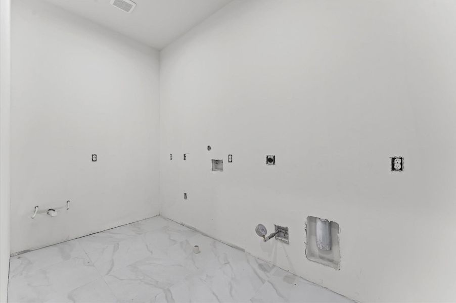 The spacious laundry room has plenty of storage and a utility sink.