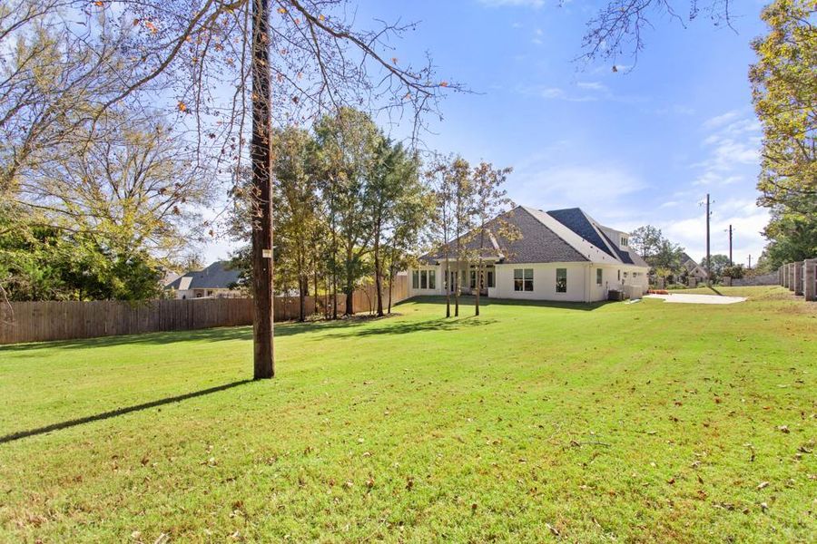 Back of property with a fenced backyard and roof with shingles
