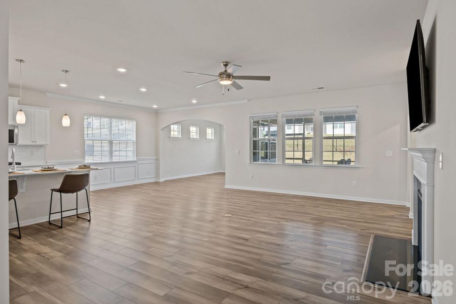 Expansive great room and dining area with recessed LED lighting, an arched entry dining/keeping room area, fireplace and wall-mounted TV.  Upgraded ceiling fans throughout.  Marble hearth.