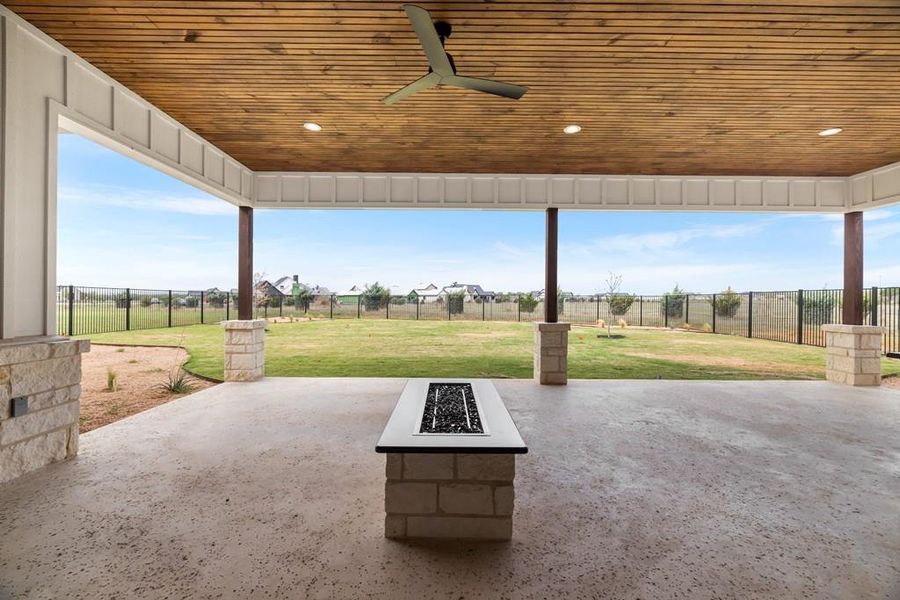 View of fenced backyard. covered patio with outdoor fire pit View of fenced backyard. covered patio with outdoor fire pit