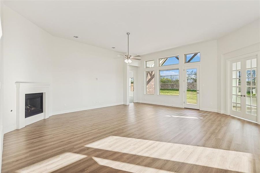 Unfurnished living room featuring light wood-type flooring and ceiling fan