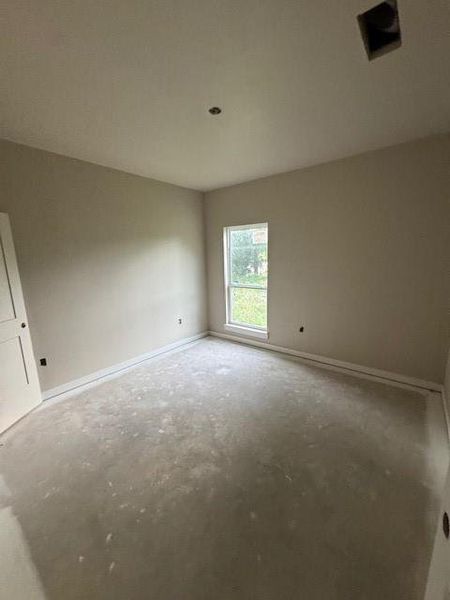 Empty room featuring unfinished concrete flooring and baseboards Empty room featuring unfinished concrete flooring and baseboards