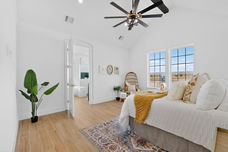 Primary Bedroom featuring wood tiled floors, a high ceiling, and a ceiling fan