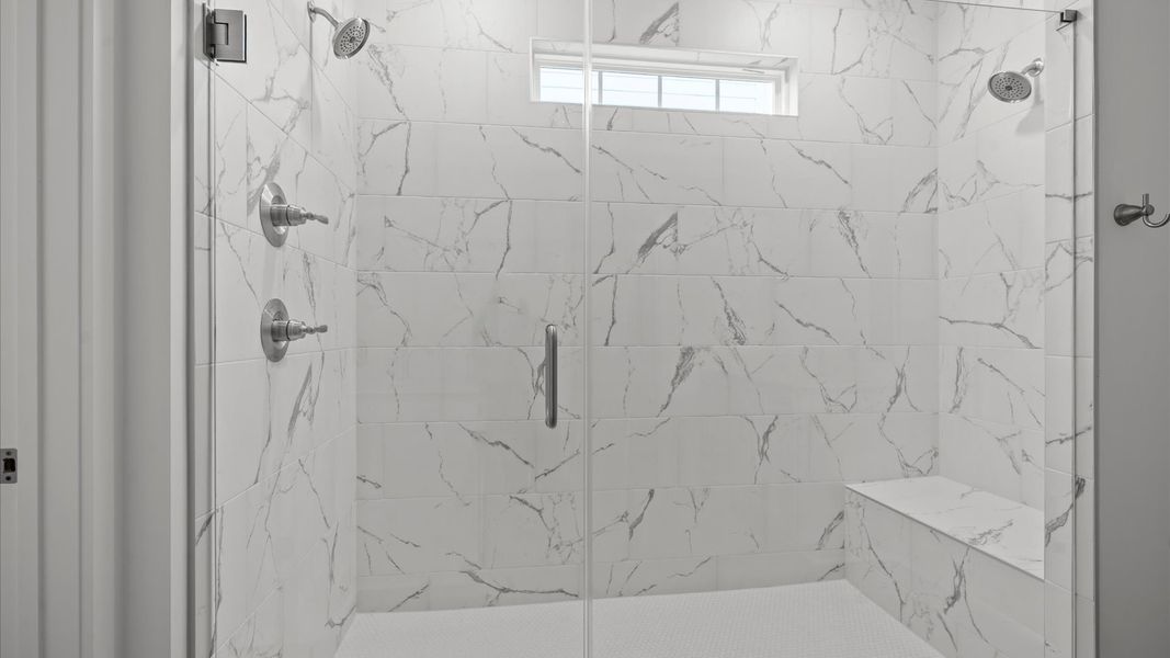 Exceptional en-suite with separate vanities and glass-enclosed tiled walk-in Roman shower for superior everyday comfort