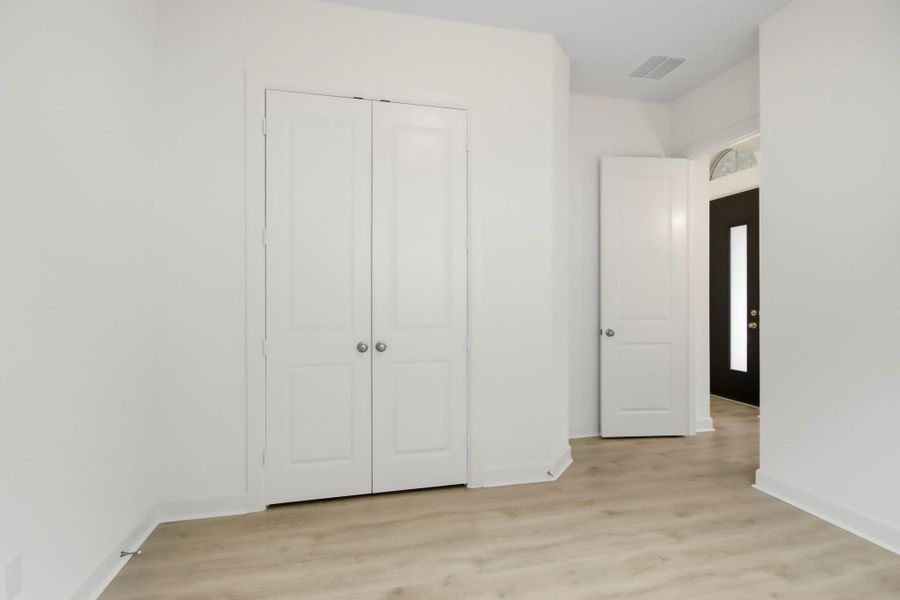Bright and inviting bedroom featuring sleek wood flooring.