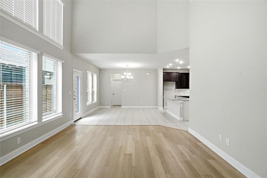 open concept living, dining and kitchen. living with 2 story ceiling and wall of eastern windows to let the sunshine in